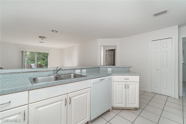 kitchen featuring white dishwasher, white cabinetry, sink, and light tile patterned floors