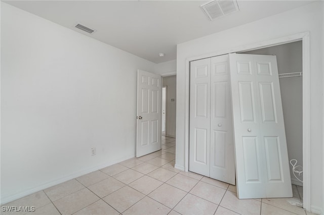 unfurnished bedroom featuring a closet and light tile patterned flooring