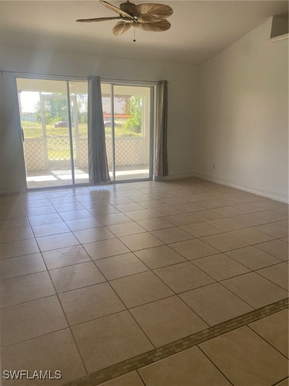 tiled spare room featuring a wealth of natural light and ceiling fan