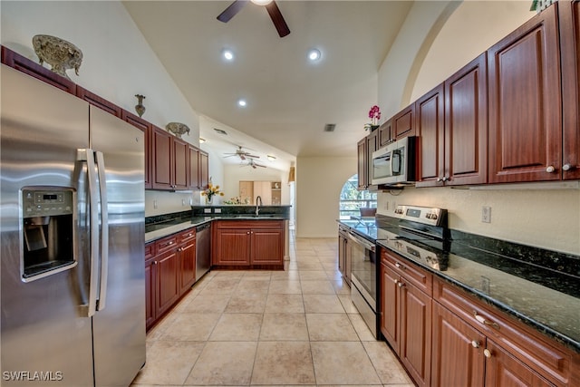 kitchen featuring appliances with stainless steel finishes, dark stone counters, sink, light tile patterned floors, and lofted ceiling