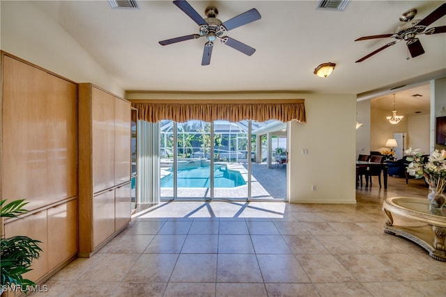 entryway with light tile patterned floors and ceiling fan with notable chandelier