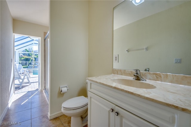 bathroom featuring tile patterned floors, a shower with door, vanity, and toilet