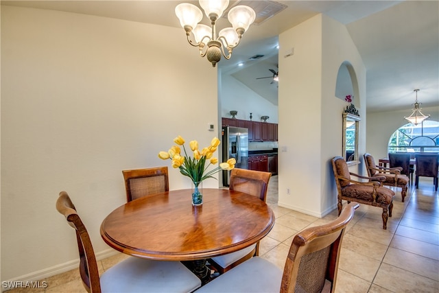 dining room featuring light tile patterned floors, ceiling fan with notable chandelier, and high vaulted ceiling