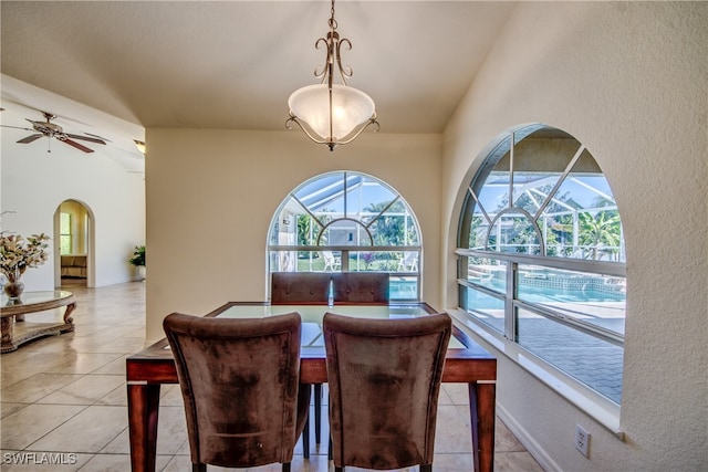 dining room with ceiling fan, light tile patterned floors, and vaulted ceiling