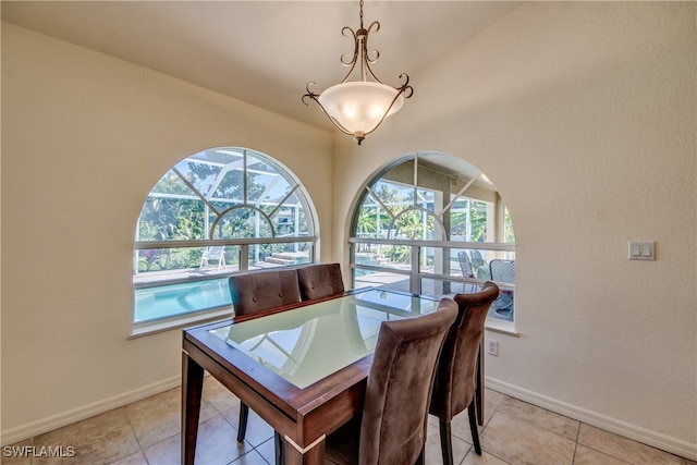 dining space with lofted ceiling and light tile patterned flooring