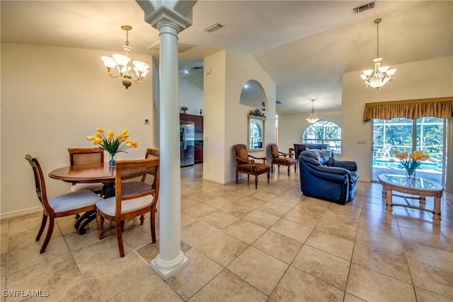 tiled dining room with decorative columns, lofted ceiling, and an inviting chandelier