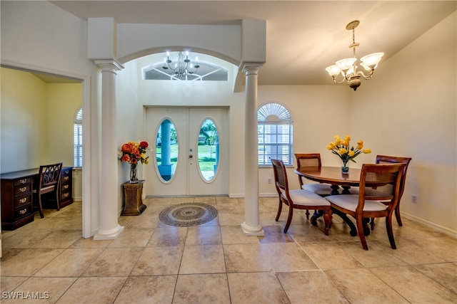 tiled foyer entrance with french doors, lofted ceiling, ornate columns, and a notable chandelier