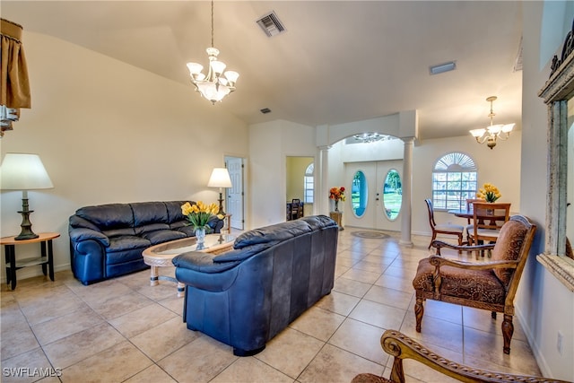 living room featuring decorative columns, light tile patterned floors, and a notable chandelier