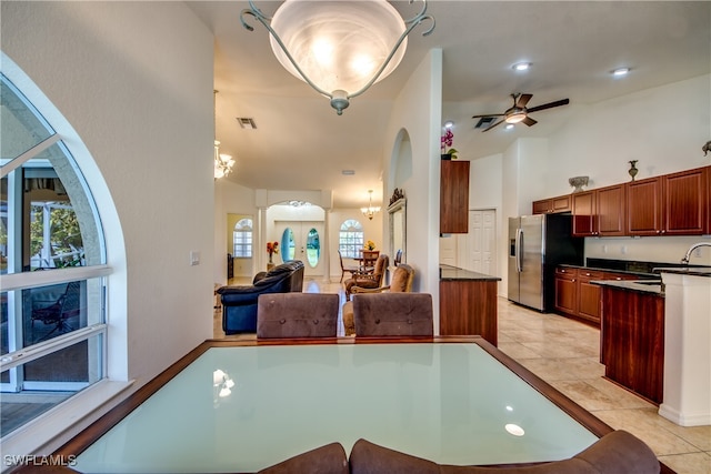 tiled dining area with vaulted ceiling and ceiling fan