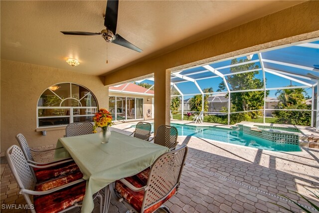 view of pool with a lanai, an in ground hot tub, ceiling fan, and a patio