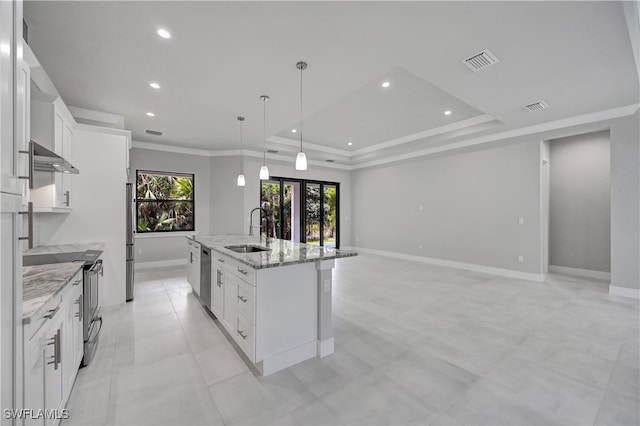 kitchen featuring sink, light stone counters, a center island with sink, white cabinets, and appliances with stainless steel finishes