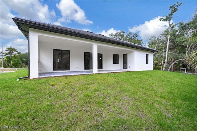 rear view of house featuring a yard and a patio