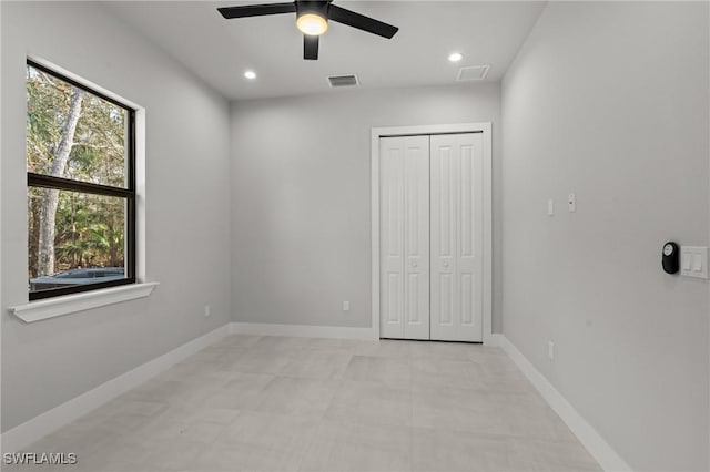 unfurnished bedroom featuring ceiling fan and a closet