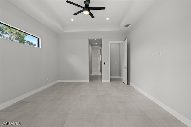 unfurnished bedroom featuring a raised ceiling and ceiling fan