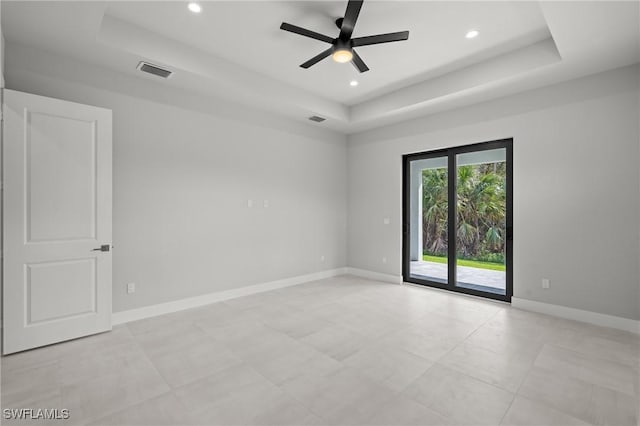 unfurnished room featuring ceiling fan and a tray ceiling