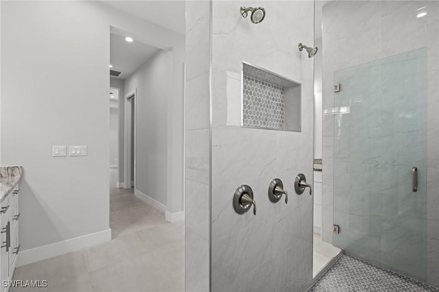 bathroom featuring vanity, a shower with shower door, and tile patterned flooring