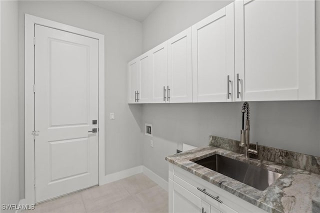 washroom with washer hookup, sink, light tile patterned floors, and cabinets