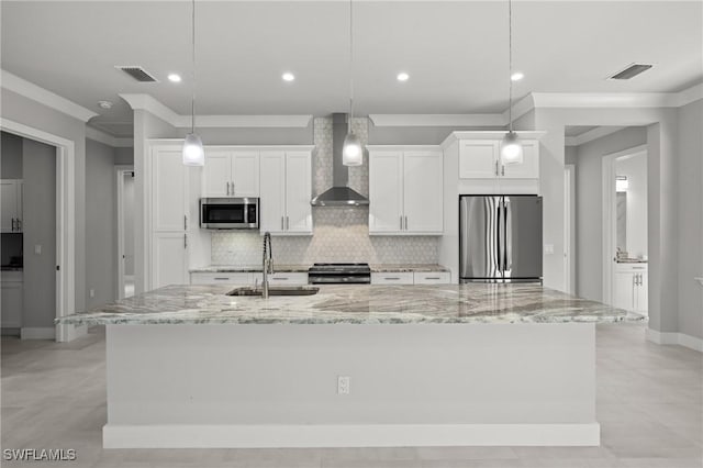 kitchen featuring wall chimney range hood, stainless steel appliances, sink, and a spacious island