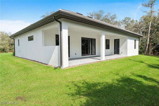 rear view of house with a yard and a patio area