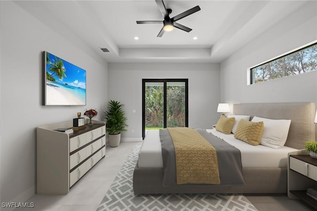 bedroom with ceiling fan and a tray ceiling