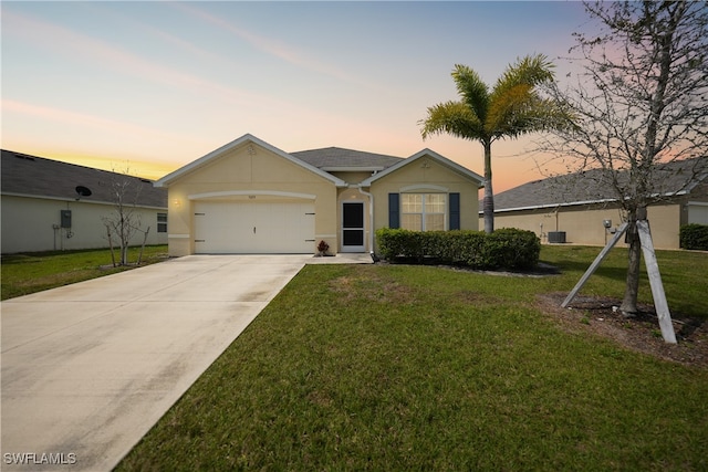 ranch-style house with a garage and a lawn