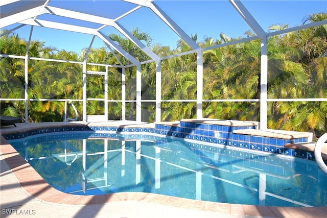 view of swimming pool featuring a lanai