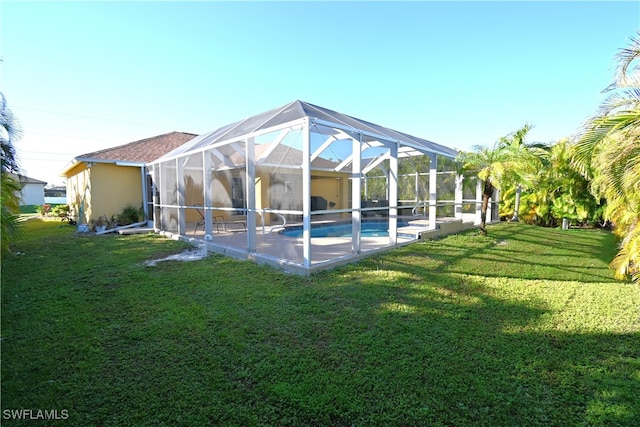 exterior space featuring glass enclosure, a patio area, and a lawn