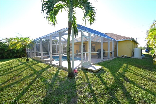 back of property featuring a lawn and a lanai