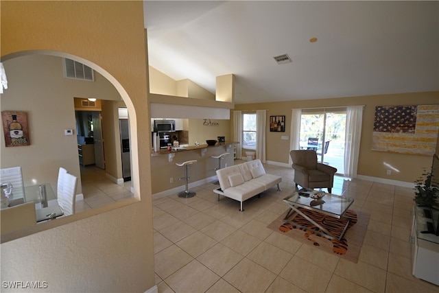 living room with light tile patterned floors and high vaulted ceiling