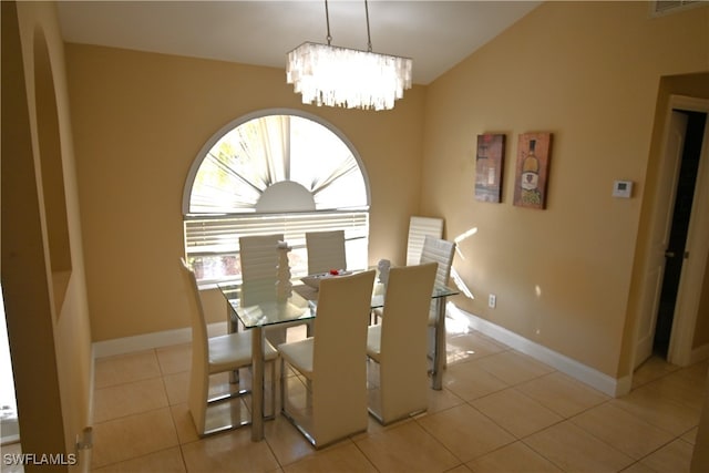 dining room with a chandelier, light tile patterned floors, and vaulted ceiling