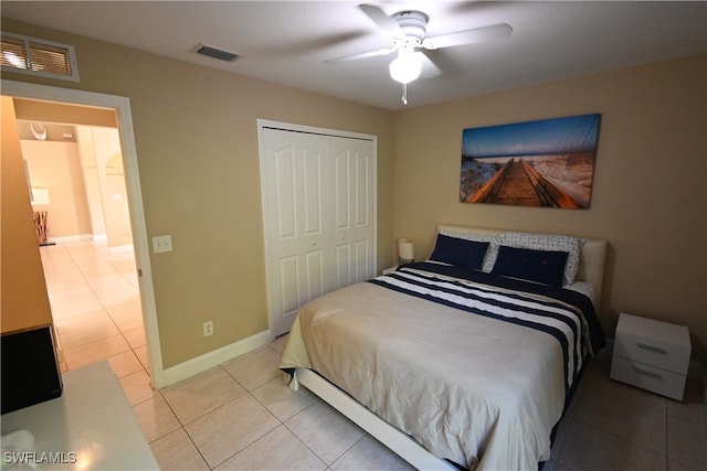 tiled bedroom featuring ceiling fan and a closet