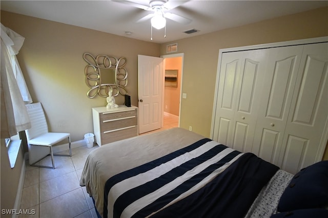 tiled bedroom with ceiling fan and a closet