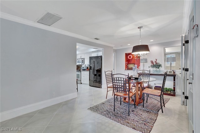 tiled dining area featuring crown molding