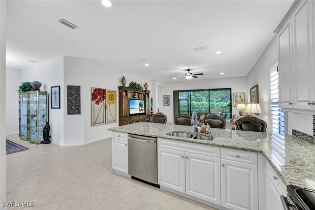 kitchen featuring kitchen peninsula, appliances with stainless steel finishes, light stone countertops, sink, and white cabinetry