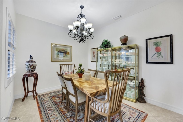 tiled dining space featuring an inviting chandelier