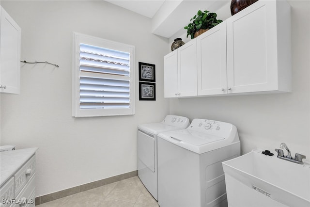 laundry room with sink, light tile patterned floors, cabinets, and independent washer and dryer