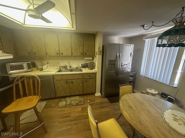 kitchen featuring ceiling fan, sink, dark wood-type flooring, stainless steel fridge with ice dispenser, and backsplash