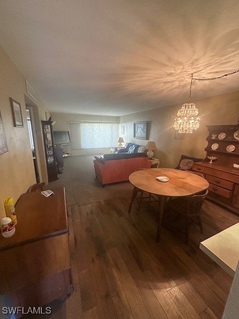 dining space featuring dark hardwood / wood-style flooring and a notable chandelier