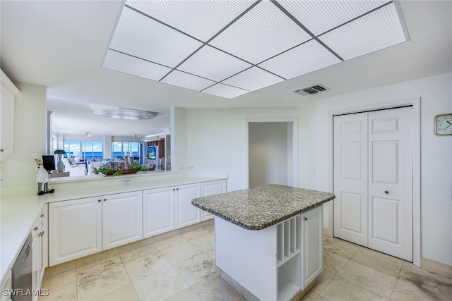 kitchen featuring white cabinets, kitchen peninsula, a kitchen island, and dishwasher