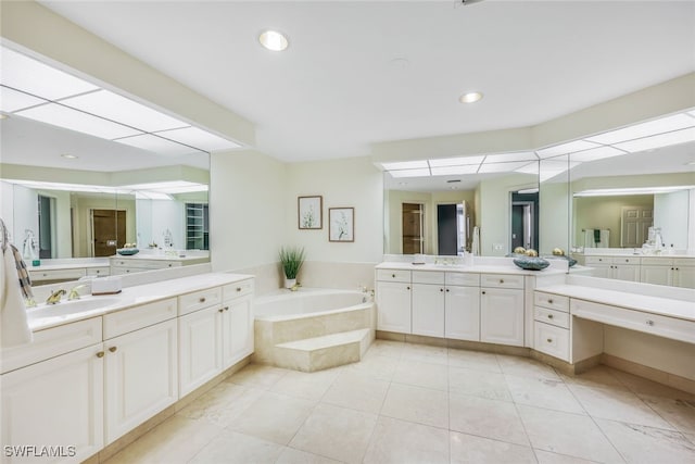 bathroom with tiled bath, tile patterned flooring, and vanity