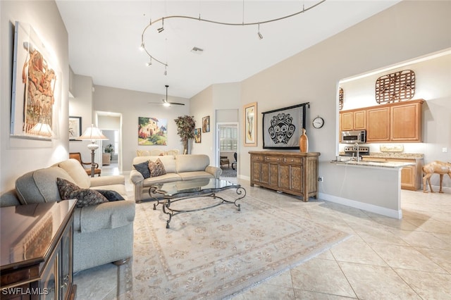 living room featuring ceiling fan, sink, light tile patterned flooring, and track lighting