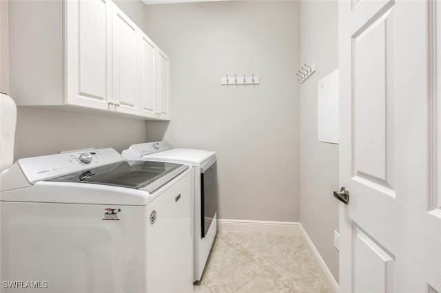 laundry area featuring cabinets, light tile patterned floors, and washer and dryer