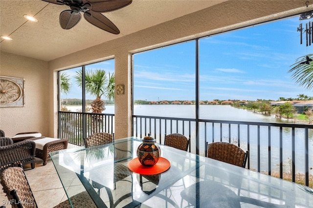 sunroom / solarium with a water view and ceiling fan