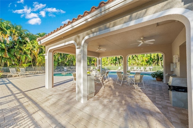 view of patio featuring ceiling fan and a community pool