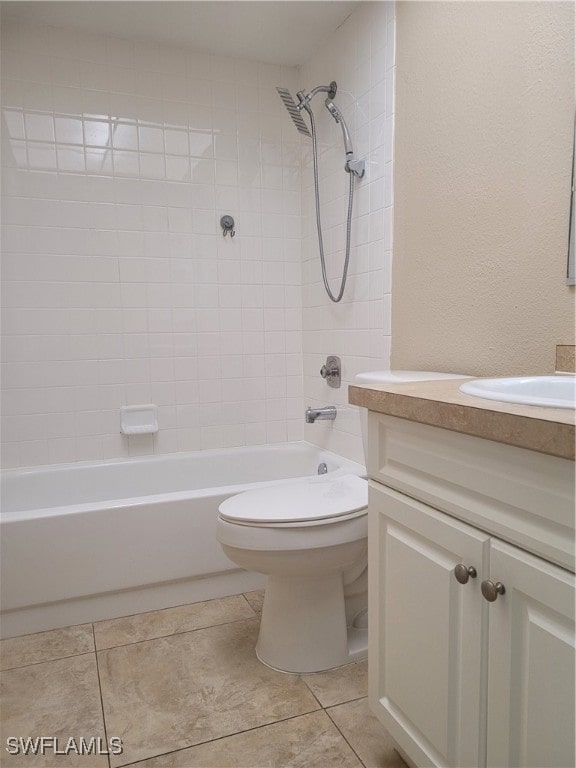 full bathroom featuring tile patterned floors, vanity, toilet, and tiled shower / bath combo