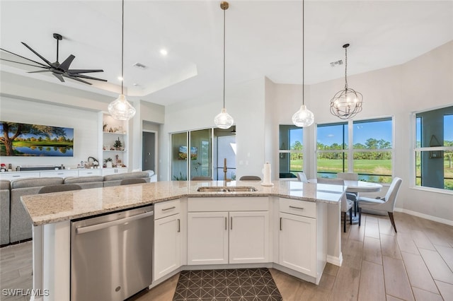 kitchen featuring white cabinets, dishwasher, light wood-type flooring, and decorative light fixtures