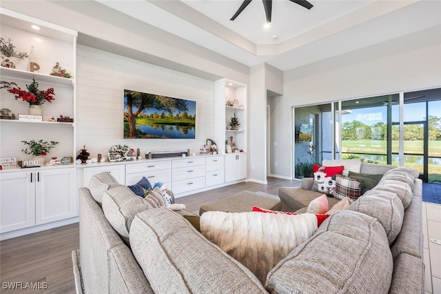 living room with hardwood / wood-style floors, ceiling fan, and built in shelves