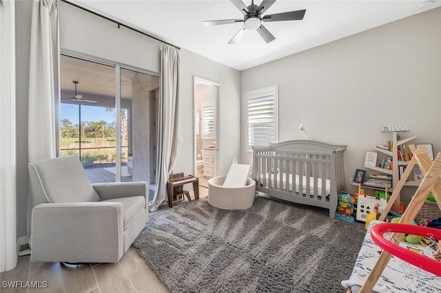 bedroom featuring ensuite bath, ceiling fan, a nursery area, and light wood-type flooring