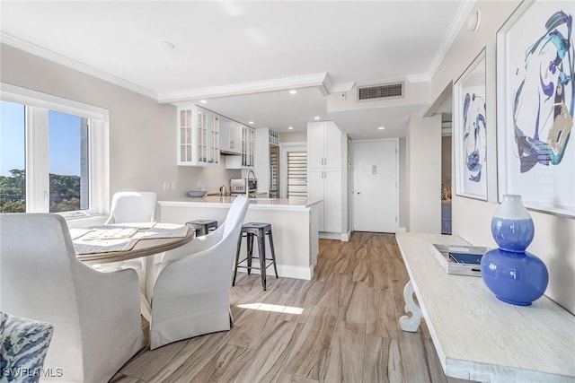 dining area featuring light hardwood / wood-style floors and ornamental molding