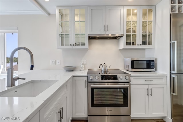 kitchen featuring crown molding, sink, light stone countertops, appliances with stainless steel finishes, and white cabinetry